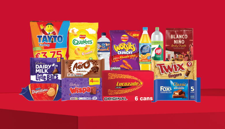 A promotional image showcasing a variety of snack foods and drinks against a red backdrop.