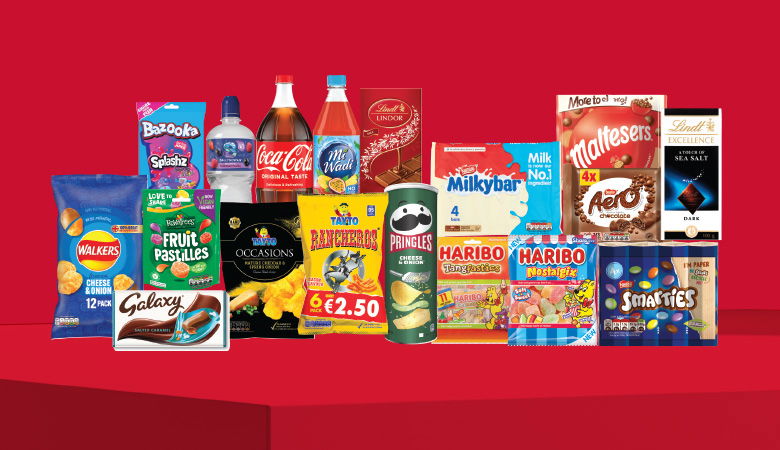 A promotional image showcasing a variety of snack foods and drinks against a red backdrop.