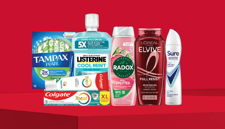 A promotional image showcasing various personal care products against a red backdrop.