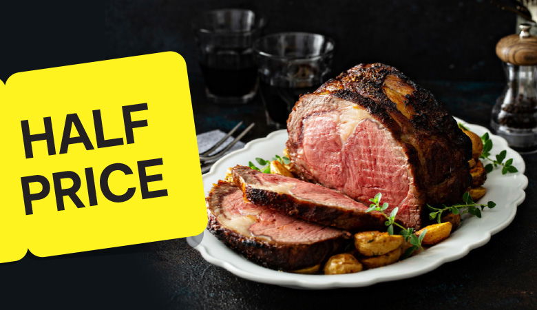 Juicy, medium-rare roast beef with a crispy, seasoned crust, sliced and served on a white platter with roasted potatoes and fresh herbs. A bold yellow sign displays 'HALF PRICE'