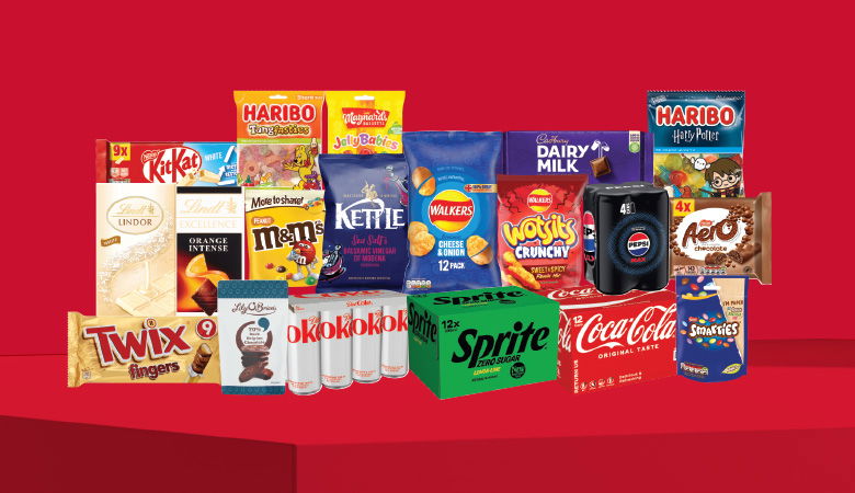 A promotional image showcasing a variety of snack foods and drinks against a red backdrop.