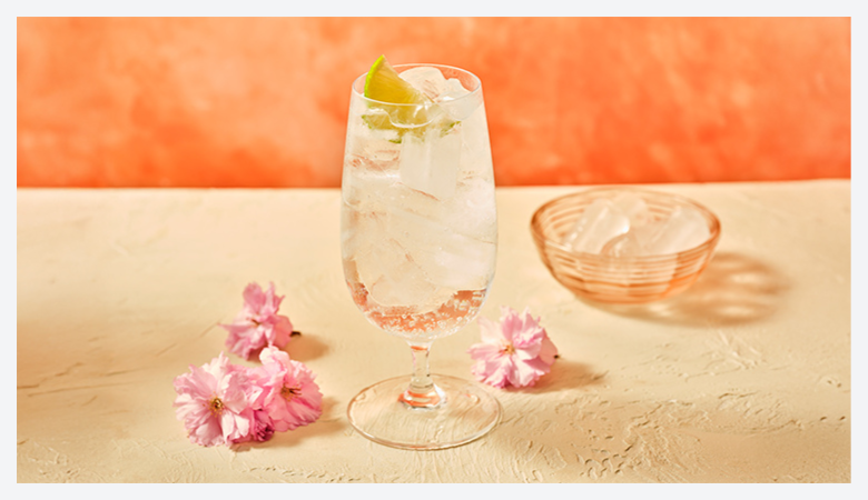 three summer beverages  in a glass with lots of ice and fruit