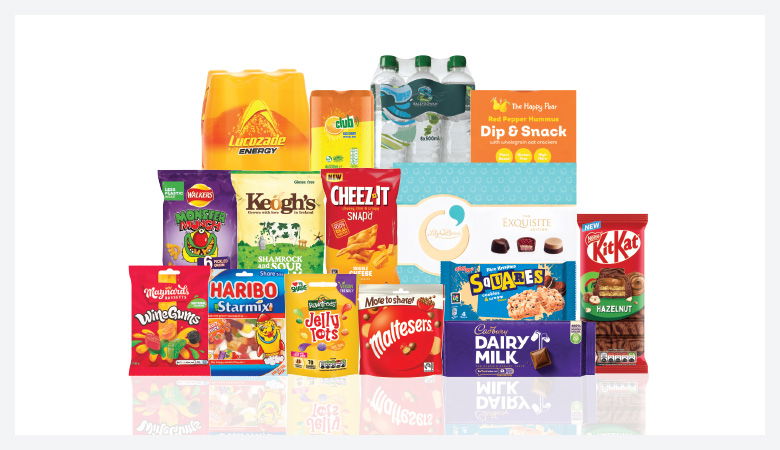 A promotional image showcasing a variety of snack foods and drinks against a red backdrop.