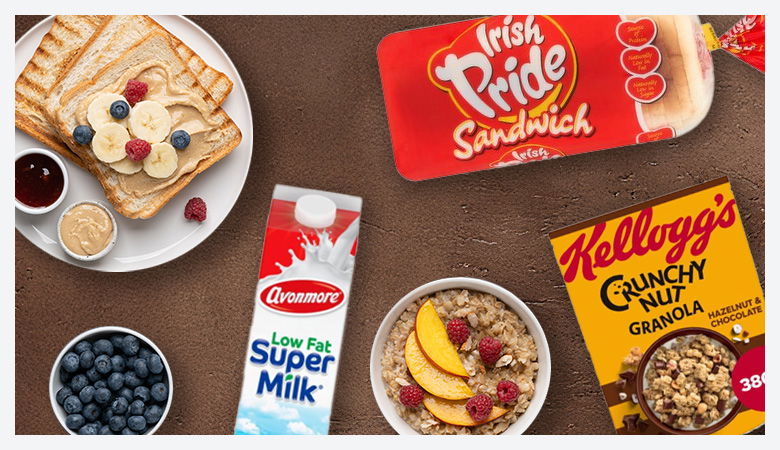 Assorted breakfast foods including cereal, yogurt, berries, and milk.
