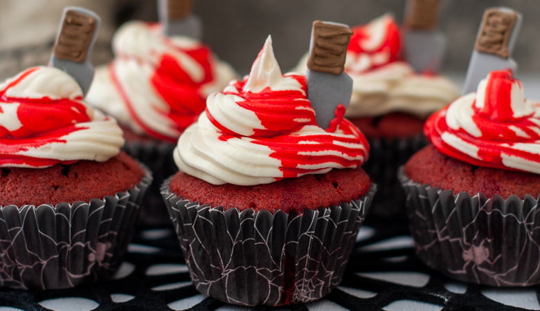 red velvet cupcake toped with butter cream and a red sauce